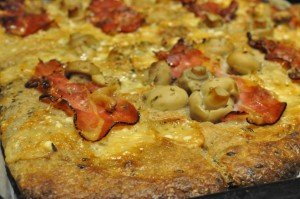Grov pizza af koldthævet dej med parmesanost og parmaskinke