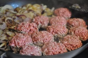 Hakkebøf med bløde, glaserede løg og pommes frites med sesam