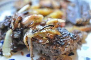 Hakkebøf med bløde, glaserede løg og pommes frites med sesam
