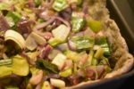 Tærte med porrer, rødløg og bacon og bund af grov tærtedej